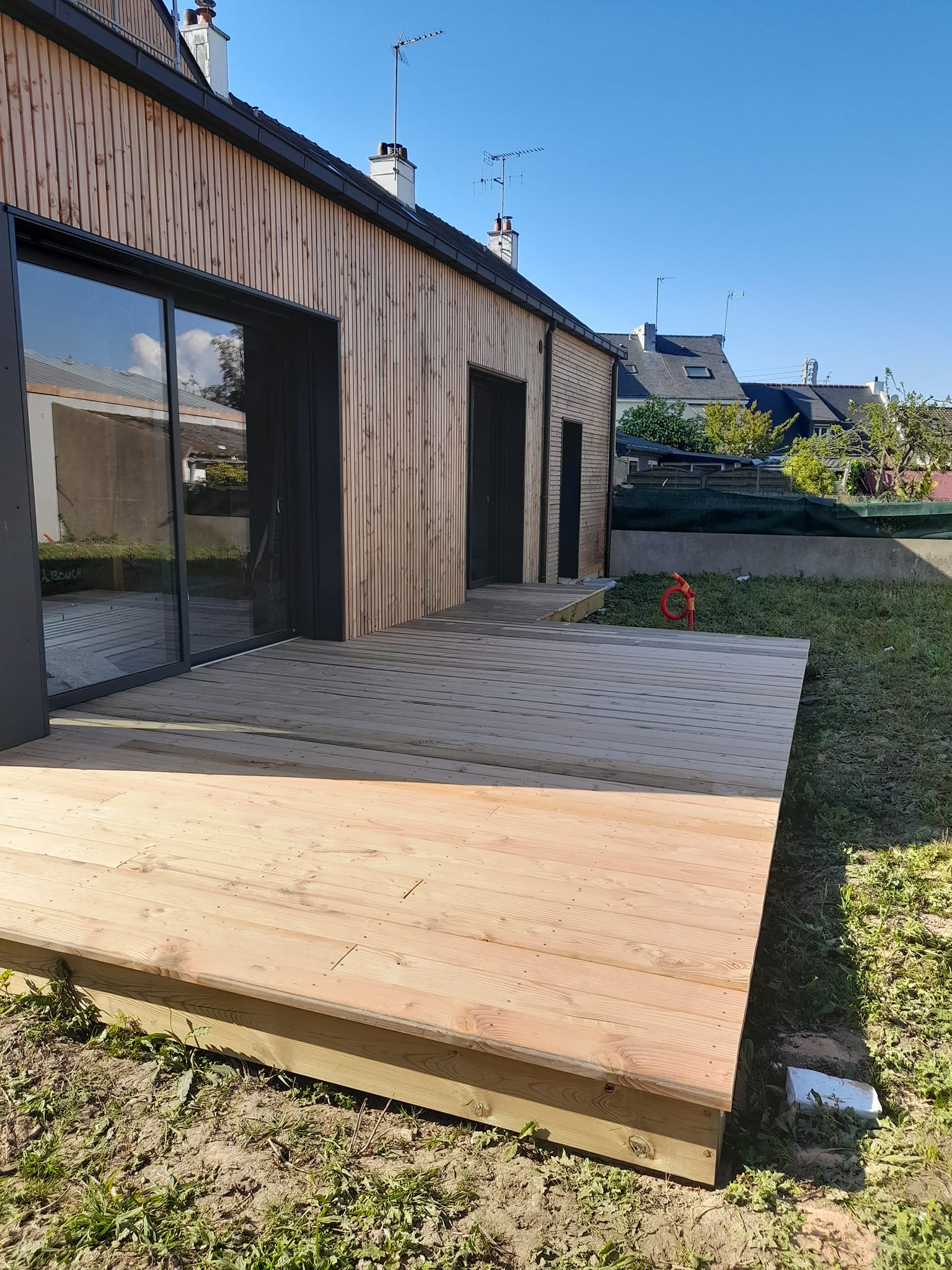 Terrasse en bois pin avec façade bardage clair